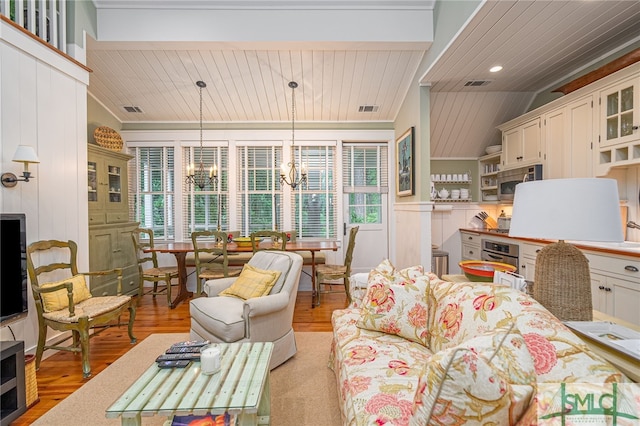 living room featuring wood ceiling, an inviting chandelier, light hardwood / wood-style flooring, and vaulted ceiling