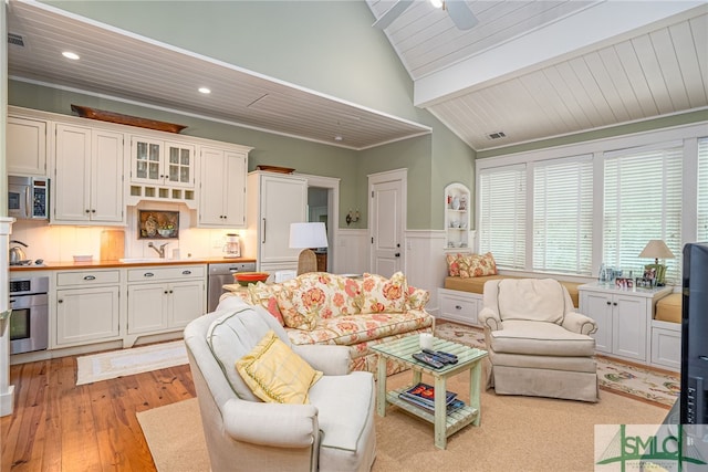 living room with wood ceiling, light hardwood / wood-style flooring, lofted ceiling with beams, and ceiling fan