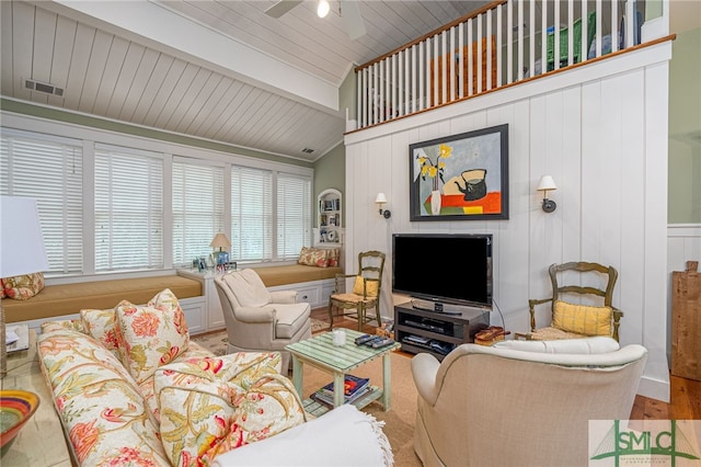 living room featuring beamed ceiling, ceiling fan, and hardwood / wood-style flooring