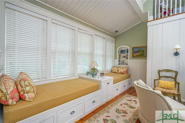 sitting room with crown molding, light hardwood / wood-style flooring, and vaulted ceiling