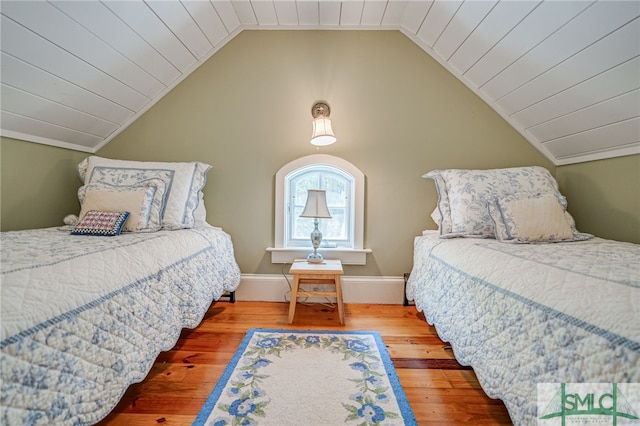 bedroom featuring hardwood / wood-style floors and lofted ceiling