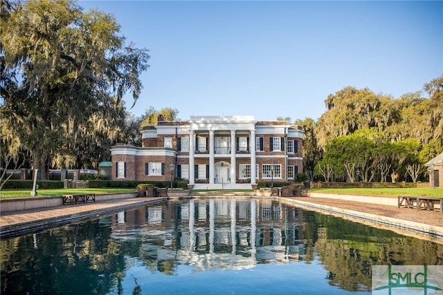 back of property featuring a water view and a balcony