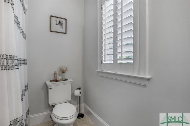 bathroom with toilet and tile floors