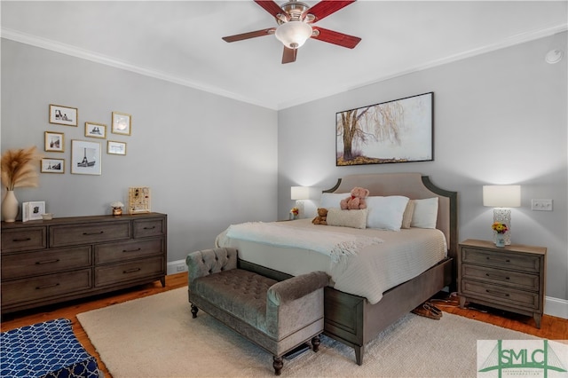 bedroom featuring ceiling fan, crown molding, and hardwood / wood-style flooring