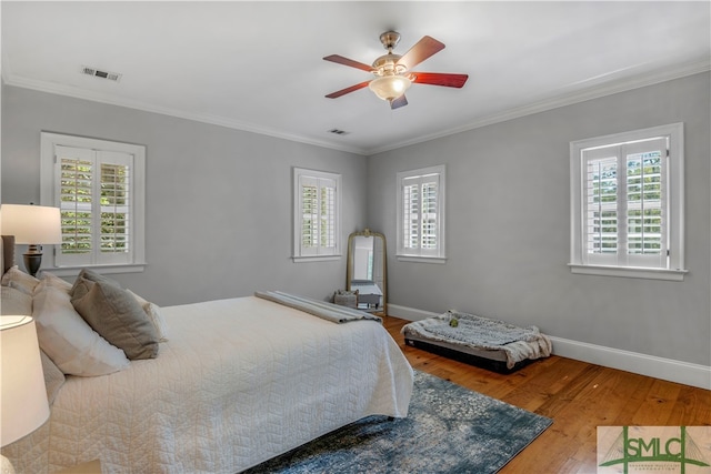 bedroom featuring ornamental molding, wood-type flooring, and ceiling fan