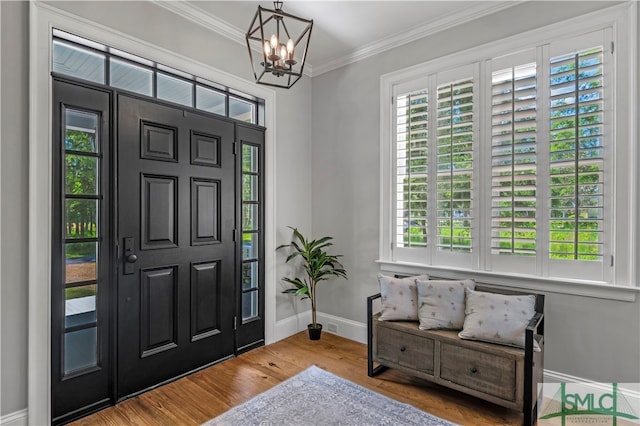 foyer featuring hardwood / wood-style floors, a notable chandelier, and crown molding