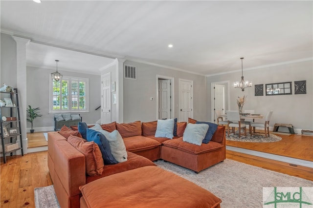 living room with hardwood / wood-style flooring, a chandelier, and decorative columns