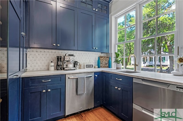 kitchen with light hardwood / wood-style flooring, blue cabinets, and dishwasher