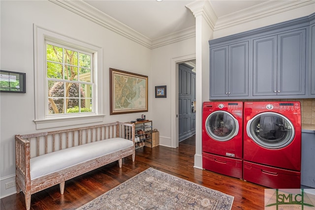 laundry area featuring dark hardwood / wood-style floors, ornamental molding, washer and clothes dryer, and cabinets