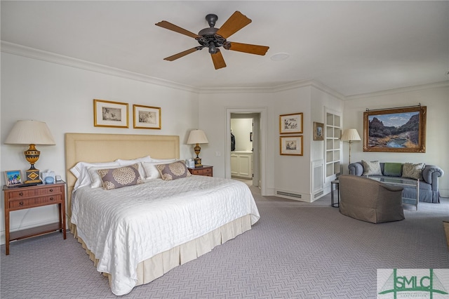 carpeted bedroom featuring ceiling fan, ensuite bath, and ornamental molding