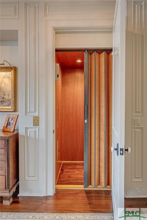 hallway with hardwood / wood-style floors