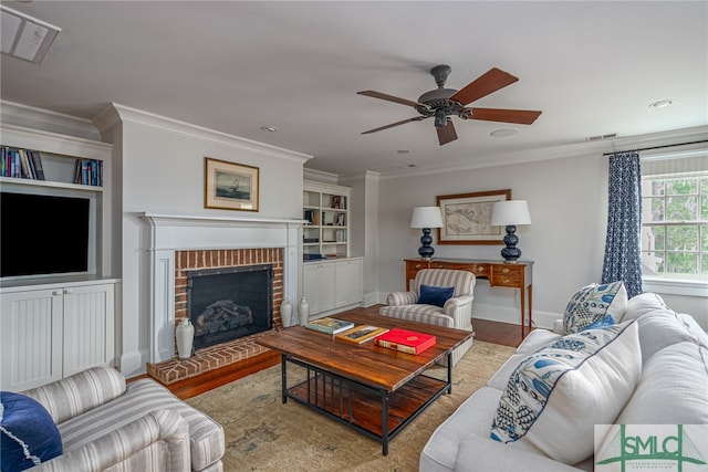 living room featuring crown molding, a brick fireplace, and hardwood / wood-style floors