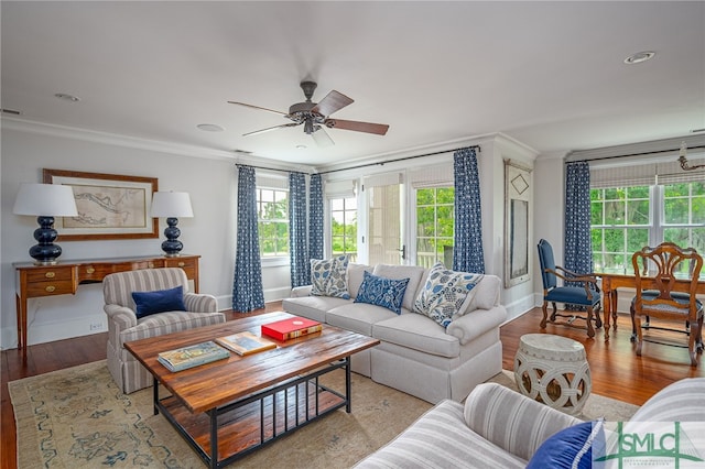 living room with wood-type flooring, ceiling fan, and crown molding