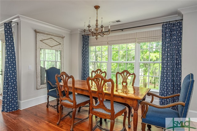 dining area featuring a wealth of natural light, ornamental molding, an inviting chandelier, and hardwood / wood-style floors