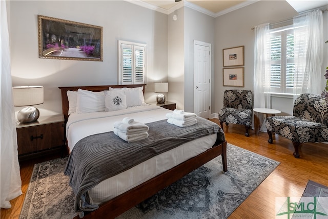 bedroom with ornamental molding, hardwood / wood-style flooring, and multiple windows