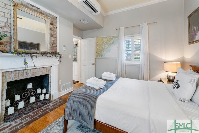 bedroom with a fireplace, an AC wall unit, and crown molding