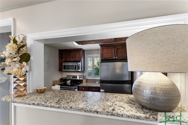 kitchen featuring appliances with stainless steel finishes, dark brown cabinetry, and light stone countertops