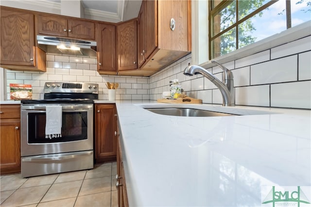 kitchen featuring decorative backsplash, ornamental molding, sink, light tile patterned floors, and stainless steel electric range oven