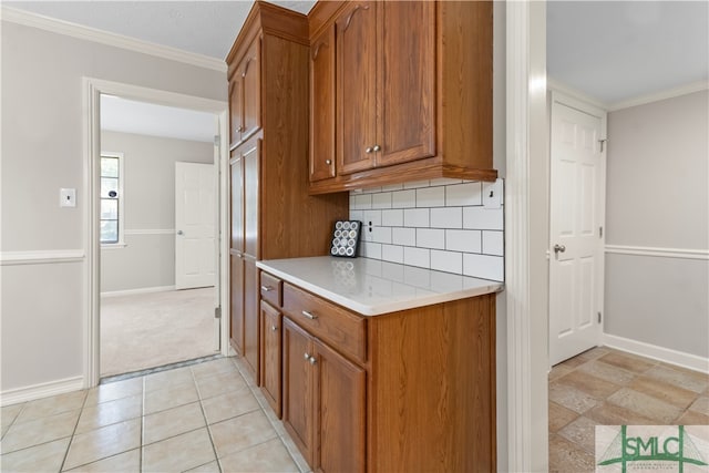 kitchen with decorative backsplash, light tile patterned floors, and crown molding