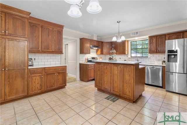 kitchen featuring ornamental molding, stainless steel appliances, decorative light fixtures, a chandelier, and a center island