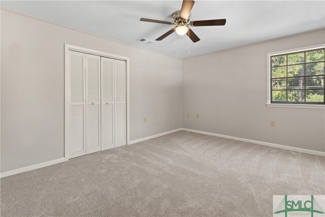 unfurnished bedroom featuring carpet flooring, ceiling fan, and a closet