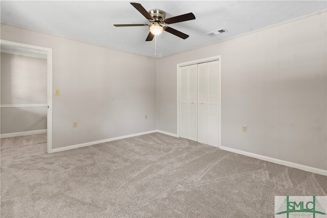 unfurnished bedroom with ceiling fan, light colored carpet, and a closet