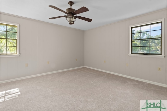 unfurnished room with light carpet, ceiling fan, and crown molding