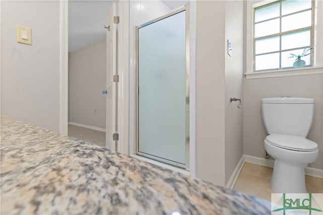 bathroom featuring tile patterned flooring, toilet, and an enclosed shower