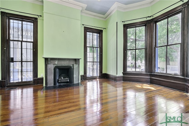 unfurnished living room featuring plenty of natural light, crown molding, hardwood / wood-style floors, and a fireplace