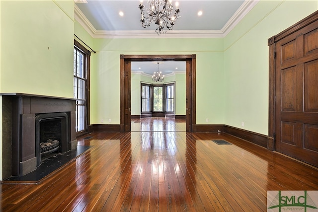 unfurnished living room with dark wood-type flooring, an inviting chandelier, and ornamental molding