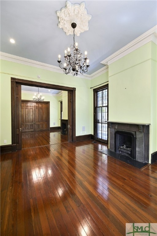 unfurnished living room with ornamental molding, a notable chandelier, and hardwood / wood-style flooring