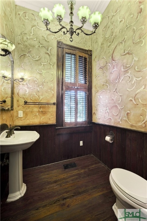 bathroom featuring wood-type flooring, wood walls, and toilet