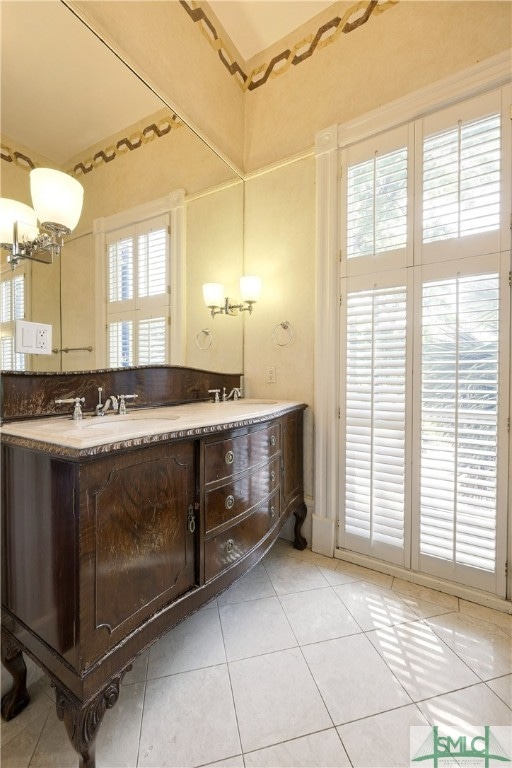 bathroom featuring a healthy amount of sunlight, tile floors, and dual bowl vanity