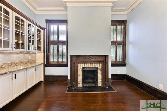 unfurnished living room featuring a wealth of natural light, crown molding, and dark hardwood / wood-style floors