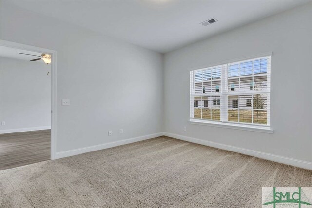 carpeted spare room featuring ceiling fan