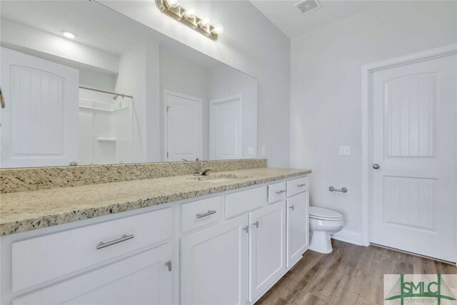 bathroom with toilet, vanity, and hardwood / wood-style flooring