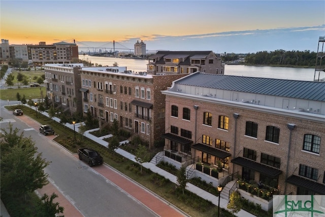 aerial view at dusk featuring a water view