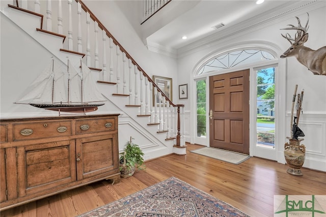 entrance foyer with ornamental molding and light wood-type flooring