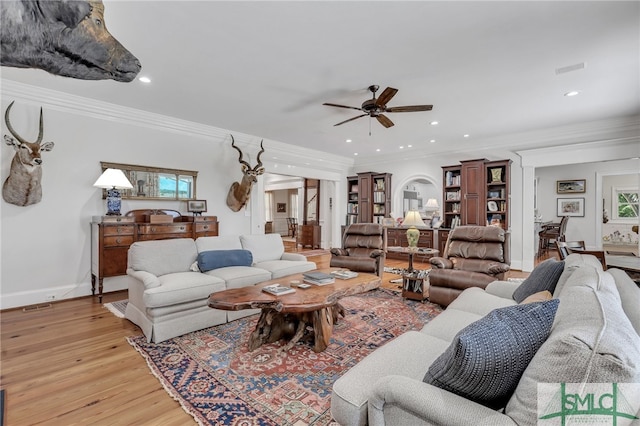 living room with ceiling fan, crown molding, and light wood-type flooring