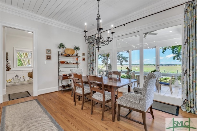 dining room with light hardwood / wood-style floors, crown molding, and an inviting chandelier