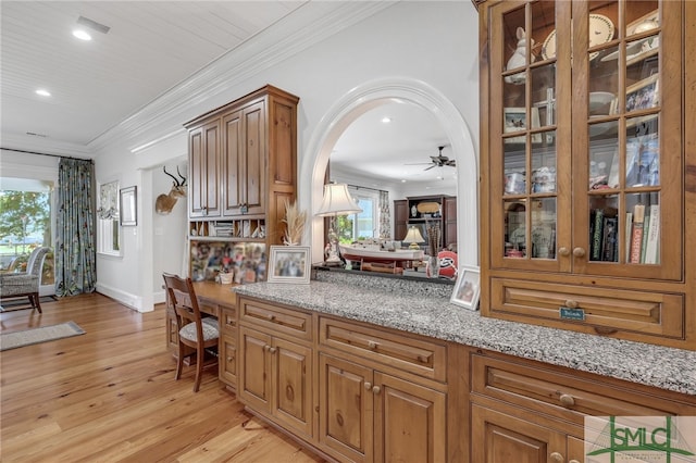 kitchen featuring light hardwood / wood-style floors, light stone countertops, crown molding, decorative light fixtures, and ceiling fan