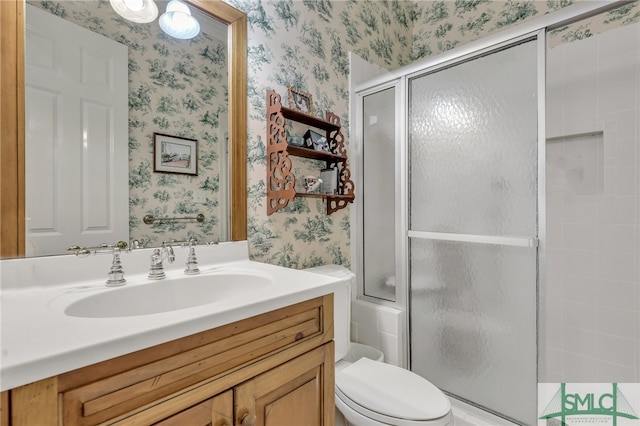 bathroom with a shower with shower door, toilet, and large vanity