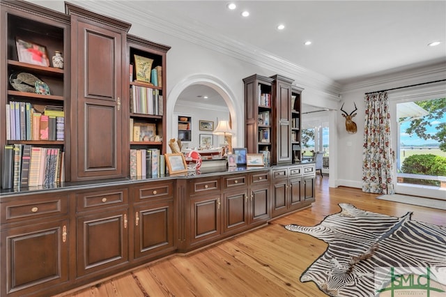 kitchen featuring light hardwood / wood-style floors, a healthy amount of sunlight, crown molding, and dark brown cabinetry