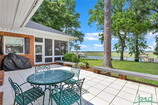 view of patio featuring a sunroom and a water view