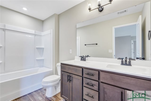 full bathroom featuring vanity, toilet, shower / washtub combination, and hardwood / wood-style floors