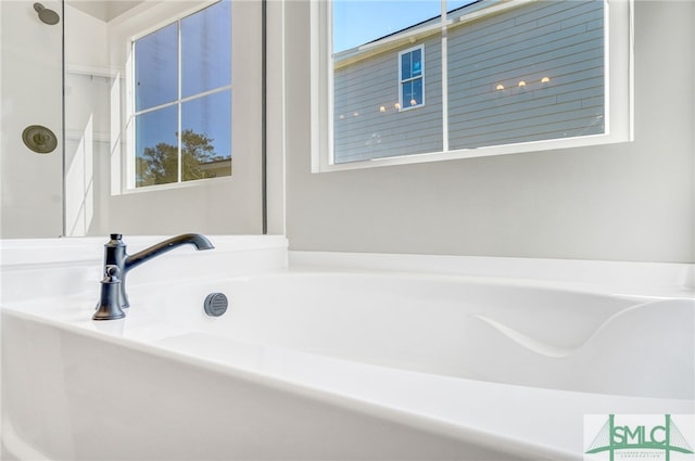 bathroom with plenty of natural light and a bath