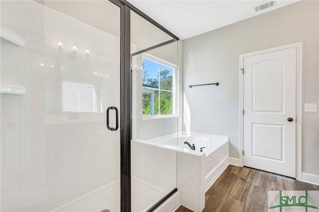 bathroom featuring separate shower and tub and hardwood / wood-style floors