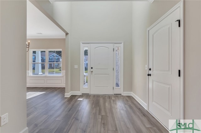 entrance foyer featuring crown molding and light hardwood / wood-style floors