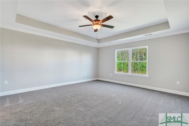 unfurnished room featuring ornamental molding, carpet, and a raised ceiling