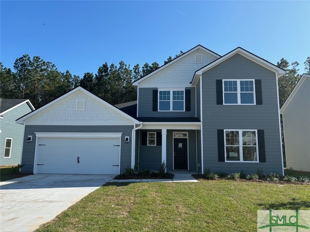 view of front of home with a front yard and a garage